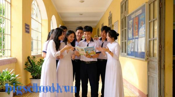 Nhóm học sinh trung học Việt Nam trong trang phục áo dài và đồng phục đang trao đổi bài học về từ vựng.